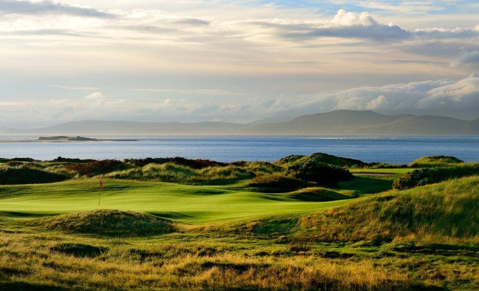 Scenic view of lush green fields and ocean near the Ring of Kerry, Killarney.