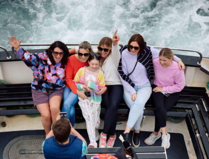 A joyful family poses on a boat ride at Killarney, creating memorable holiday moments.