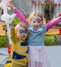 Two children with face paint playing at Park Place Apartments, Killarney, with balloons in hand.