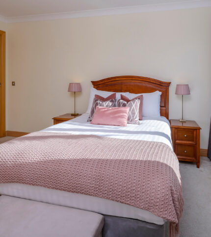 Elegant bedroom with soft pink accents at Park Place Apartments in Killarney, ideal for families.