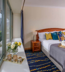 Cosy bedroom with mountain view at Park Place Apartments, featuring a breakfast spread.