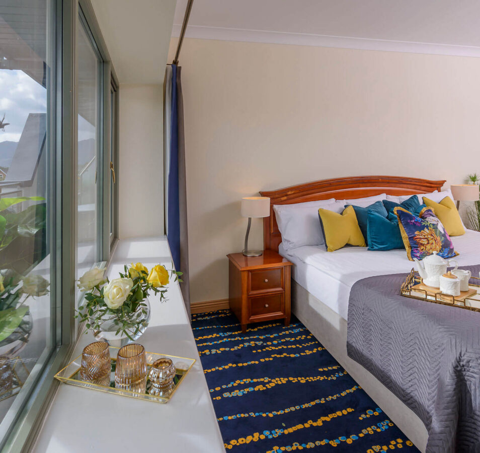 Cosy bedroom with mountain view at Park Place Apartments, featuring a breakfast spread.