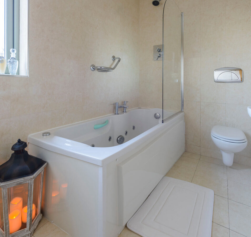 Inviting bathroom with bathtub and lantern at Park Place Apartments, Killarney.