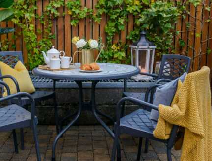 Cosy outdoor seating at Park Place Apartments with tea set and pastries on table.