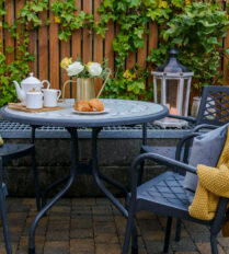 Cosy outdoor seating at Park Place Apartments with a tea set and croissants on the table.