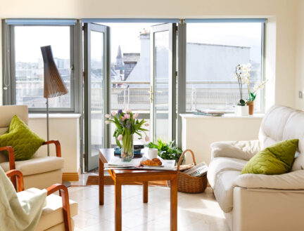 Bright living room in Park Place Apartments, Killarney, with flowers on a table and scenic views.