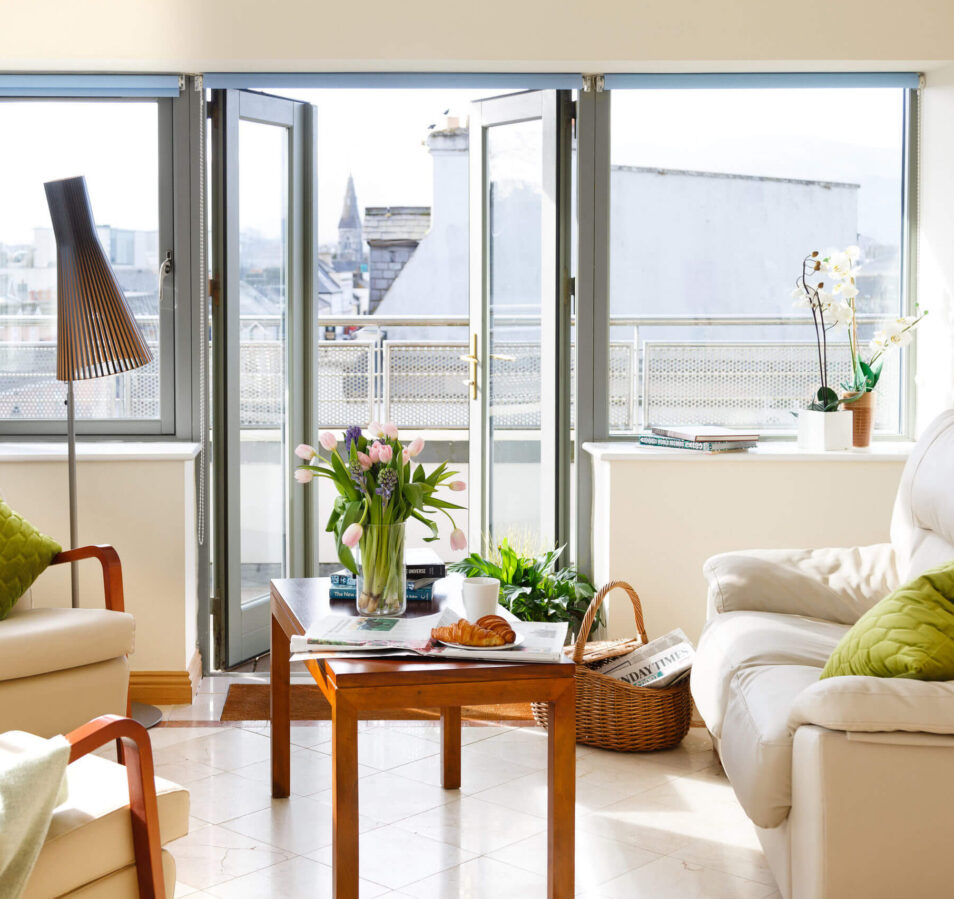 Bright living room in Park Place Apartments, Killarney, with flowers on a table and scenic views.