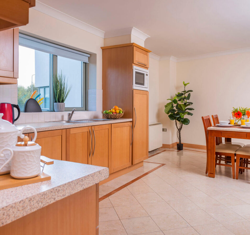 Bright, inviting kitchen and dining area with wooden furniture at Park Place Apartments, Killarney.
