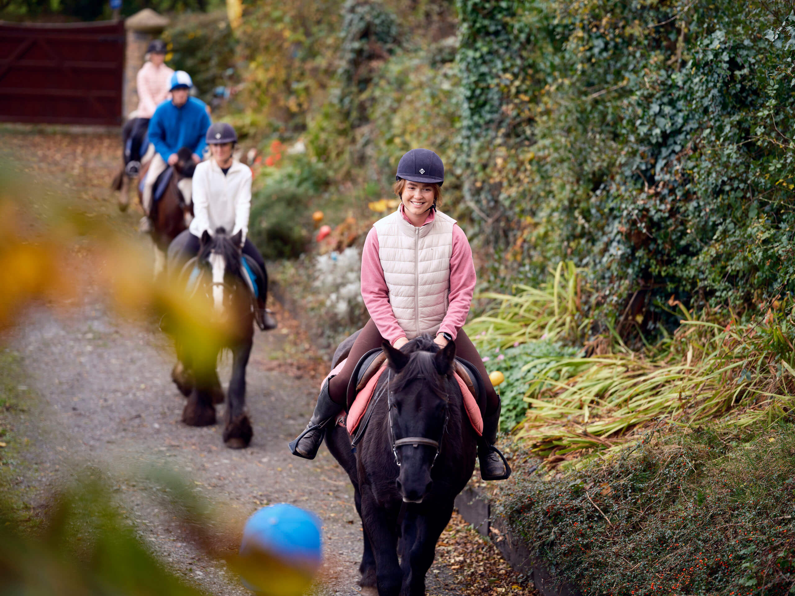 A family enjoys horse riding through lush greenery near Killarney, highlighting Park Place Apartments' nearby attractions.
