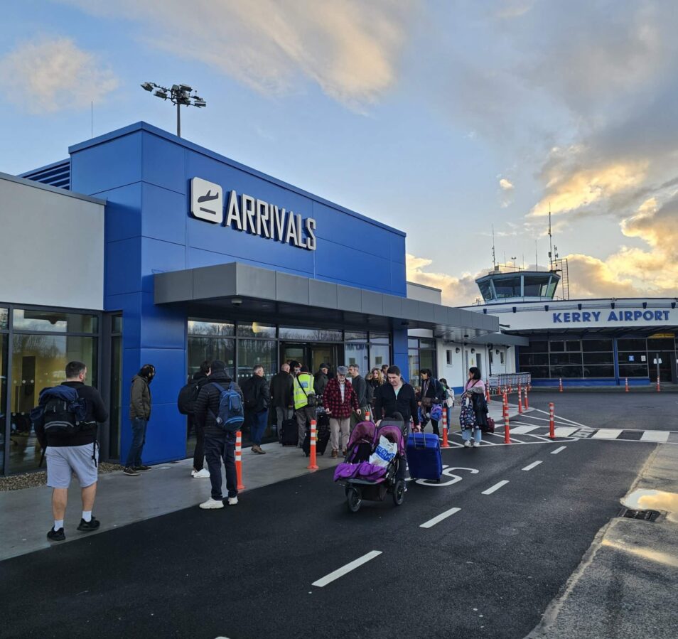 A family arrives at Kerry Airport, near Park Place Apartments, Killarney, under a vibrant sky.