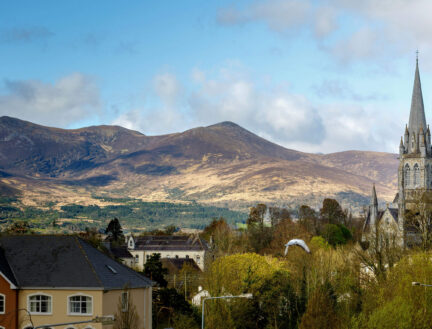 Picturesque view of mountains and church near Park Place Apartments in Killarney.