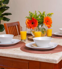 A cosy dining table set with bowls and glasses of orange juice at Park Place Apartments.