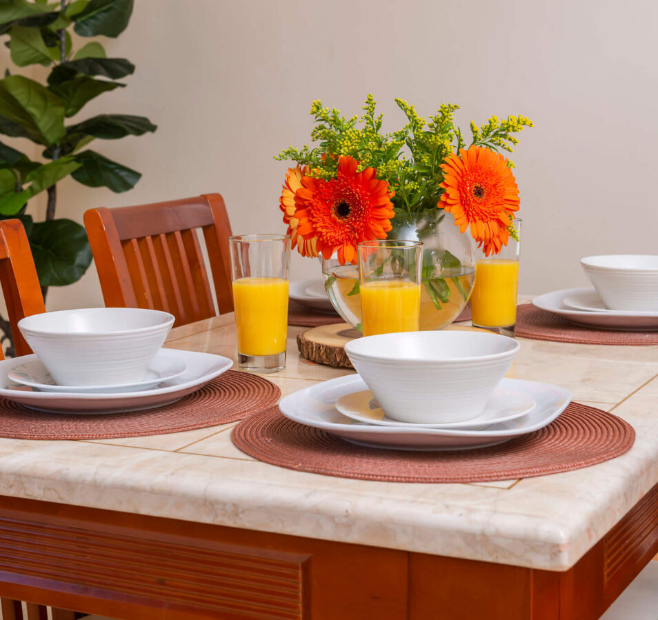 A cosy dining table set with bowls and glasses of orange juice at Park Place Apartments.