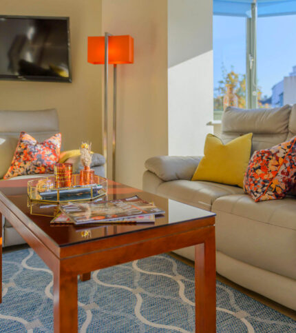 Bright, cosy living room in Park Place Apartments, Killarney, with comfortable sofas and vibrant cushions.