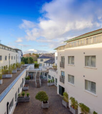 Modern courtyard of Park Place Apartments in Killarney under blue skies.