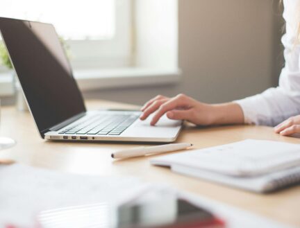 Woman using a laptop at a bright, cosy desk in Park Place Apartments, Killarney.