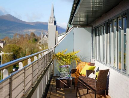 Balcony view at Park Place Apartments with comfy seating, vibrant cushions, and scenic mountains.