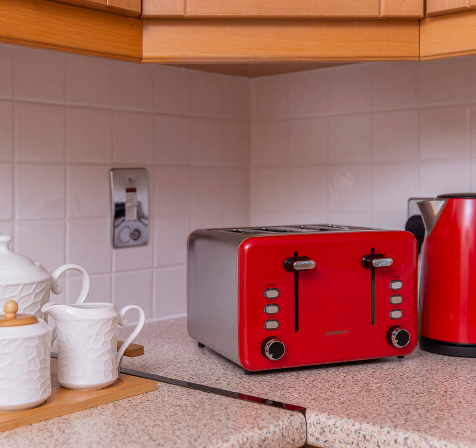 Modern kitchen corner with a red toaster and kettle at Park Place Apartments.