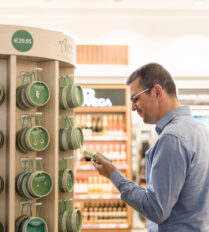 A man shops for jewellery in a bright store, browsing items priced at €29.95.