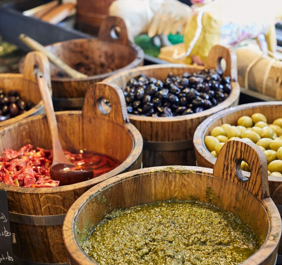 Rustic wooden bowls filled with pesto, olives, and sun-dried tomatoes at Park Place Apartments.