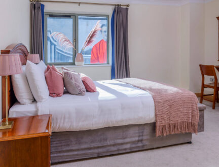 Cosy bedroom at Park Place Apartments with pastel decor and natural lighting.