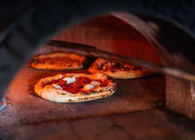 Wood-fired pizzas cooking in a traditional oven at Park Place Apartments, Killarney.