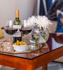 Cosy living room with wine, olives, and flowers at Park Place Apartments, Killarney.